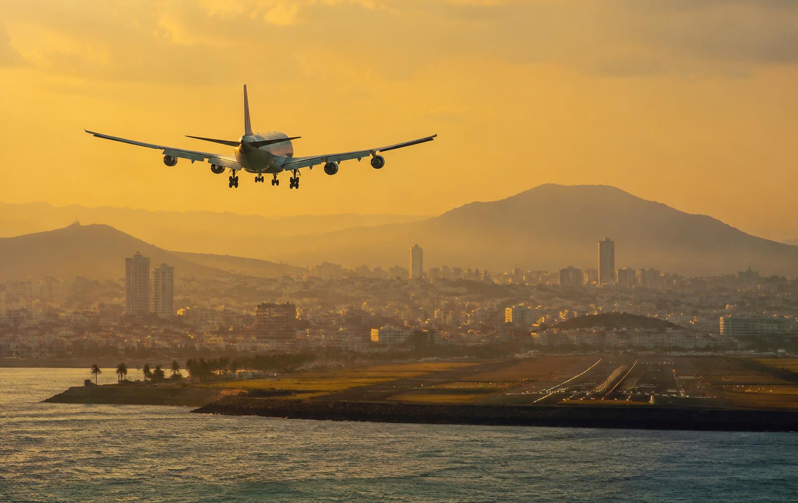 Aircraft on final approach over a coastal city
